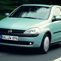 Jasnozielony Opel Corsa C na drodze, z widocznym logo i tablicą rejestracyjną.
