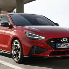 Czerwony Hyundai i30 N Line w ruchu, z widocznym przodem i bokiem.