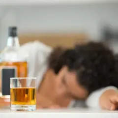 Szklanka z alkoholem i butelka obok śpiącej osoby. Nie ma sposobu, jak sprawdzić promile bez alkomatu.