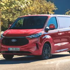 Czerwony Ford Transit Custom w ruchu. Zastanawiasz się nad jego pojemnością baku? Ten van jest gotowy na długie trasy.