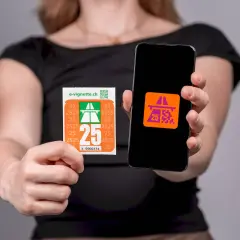 Kobieta pokazuje naklejkę i ekran telefonu z symbolem autostrady, symbolizującym winietę szwajcaria.