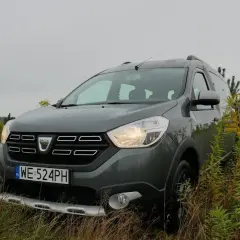 Szary Dacia Dokker na tle jesiennej przyrody. Zastanawiasz się nad jego **pojemnością baku**?