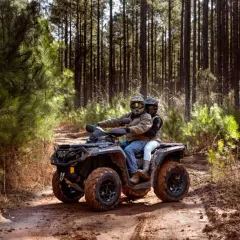 Para quad 125 potrzebne jest prawo jazdy kategorii B. Para na quadzie przemierza leśną ścieżkę.