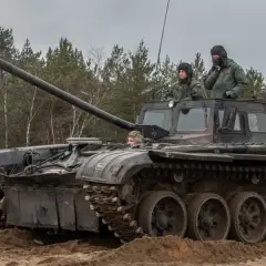Szkolenie z zakresu jak zostać kierowcą czołgu. Trzech żołnierzy w wojskowych pojazdach, jeden z nich siedzi w otwartym włazie, dwóch innych w kabinie.