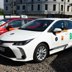 Białe i czerwone samochody z logo Bolt, gotowe do jazdy. Dowiedz się, jak zostać kierowcą Bolt i zacznij zarabiać.