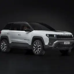 Biały Jeep Compass na ciemnym tle. Zwróć uwagę na jego nowoczesny design i wymiary, idealne do miasta i w teren.
