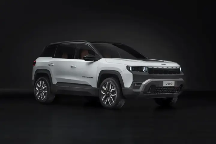 Biały Jeep Compass na ciemnym tle. Zwróć uwagę na jego nowoczesny design i wymiary, idealne do miasta i w teren.