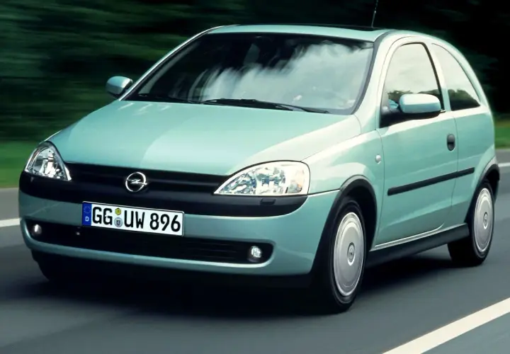 Jasnozielony Opel Corsa C na drodze, z widocznym logo i tablicą rejestracyjną.