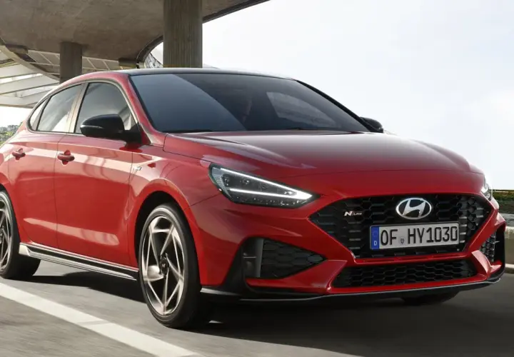 Czerwony Hyundai i30 N Line w ruchu, z widocznym przodem i bokiem.