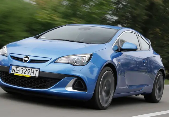 Niebieski Opel Astra G w ruchu, widok z przodu i z boku.