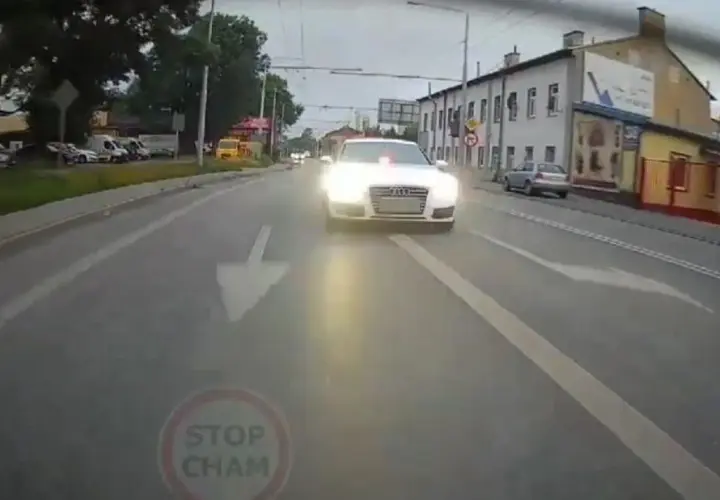 Białe Audi S7 z włączonymi światłami i sygnałem świetlnym jedzie ulicą. Kierowca tego auta prawdopodobnie spieszy się na interwencję.