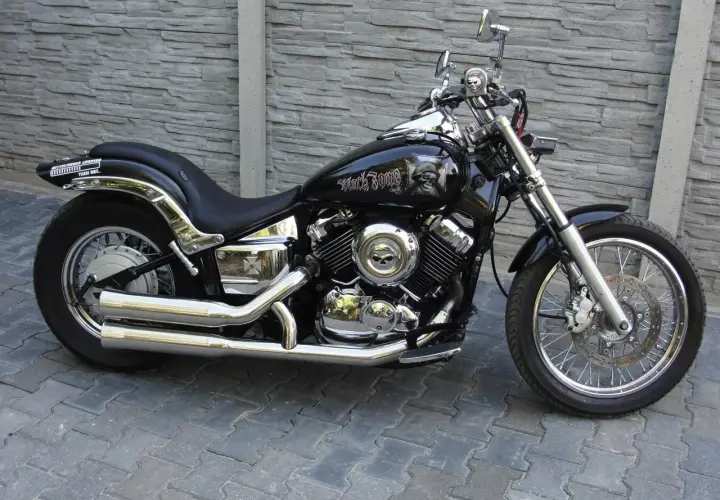 Czarny motocykl Yamaha Drag Star 650 z ozdobami czaszek. Pojemność baku pozwala na długie podróże.