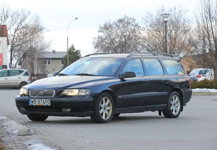 Ciemny czarny kombi Volvo V70 zaparkowany na zewnątrz.