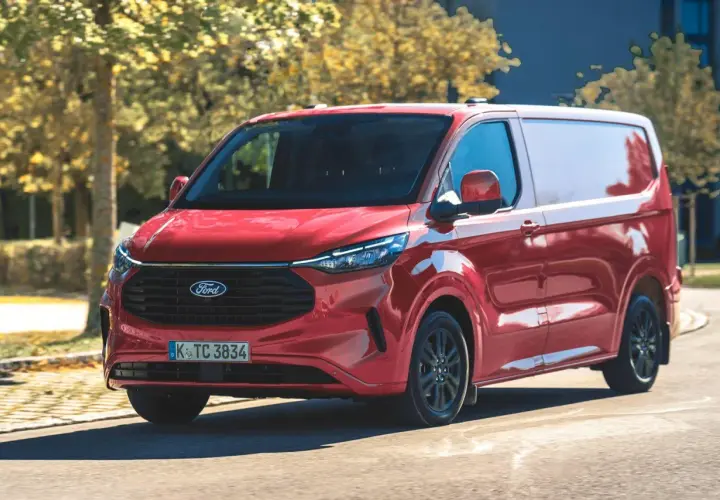 Czerwony Ford Transit Custom w ruchu. Zastanawiasz się nad jego pojemnością baku? Ten van jest gotowy na długie trasy.