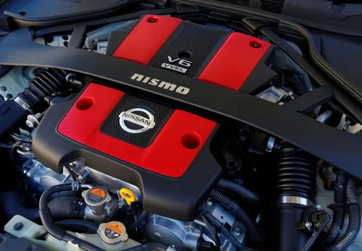 Silnik V6 Nismo z czerwonymi pokrywami zaworów, gotowy do generowania potężnego momentu obrotowego.