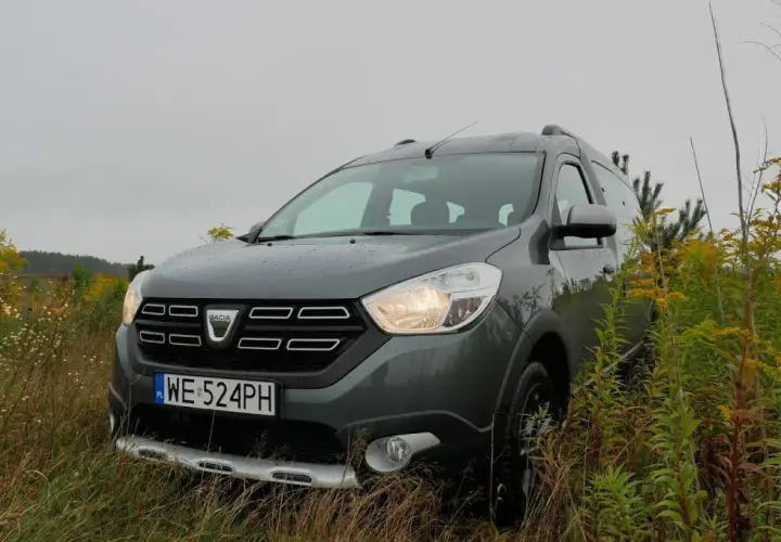 Szary Dacia Dokker na tle jesiennej przyrody. Zastanawiasz się nad jego **pojemnością baku**?