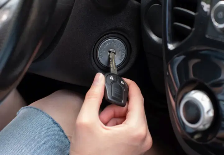 Ręka wkłada kluczyk do stacyjki. Czy to pomoże, jak odpalić samochód z uszkodzonym immobilizerem?