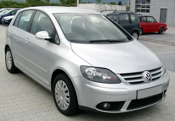 Srebrny Volkswagen Golf Plus zaparkowany na kostce brukowej.