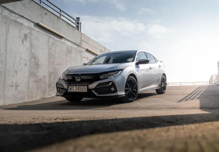 Srebrna Honda Civic 7 na tle betonowej ściany i nieba.