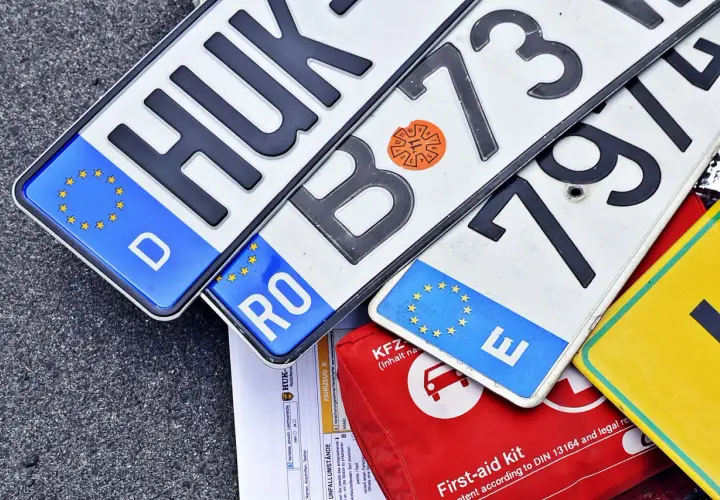 Niemieckie, rumuńskie i inne tablice rejestracyjne państw UE leżą obok apteczki.