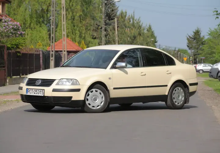 Jasny beżowy Volkswagen Passat B5 sedan na drodze.