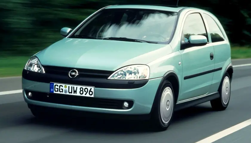 Jasnozielony Opel Corsa C na drodze, z widocznym logo i tablicą rejestracyjną.