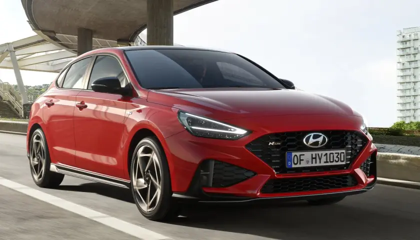 Czerwony Hyundai i30 N Line w ruchu, z widocznym przodem i bokiem.