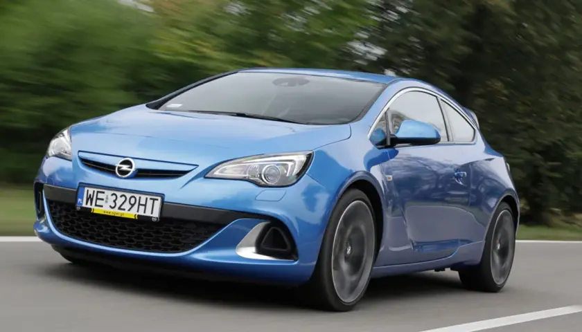 Niebieski Opel Astra G w ruchu, widok z przodu i z boku.