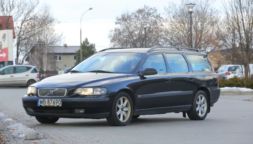 Ciemny czarny kombi Volvo V70 zaparkowany na zewnątrz.