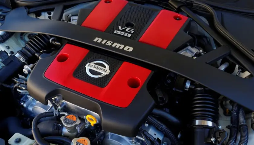 Silnik V6 Nismo z czerwonymi pokrywami zaworów, gotowy do generowania potężnego momentu obrotowego.