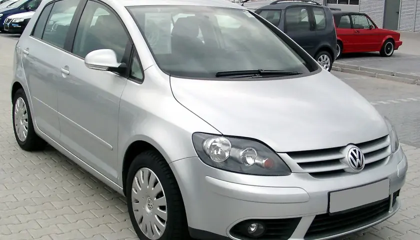 Srebrny Volkswagen Golf Plus zaparkowany na kostce brukowej.
