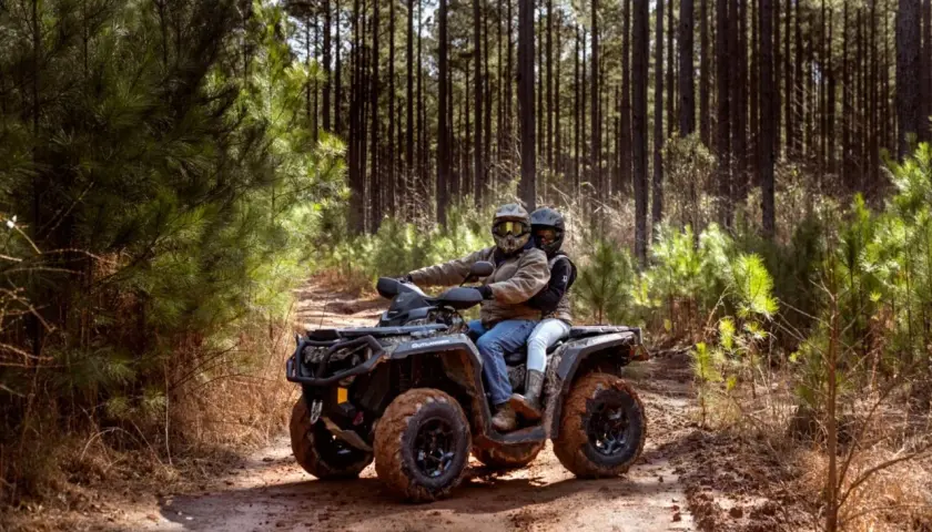 Para quad 125 potrzebne jest prawo jazdy kategorii B. Para na quadzie przemierza leśną ścieżkę.
