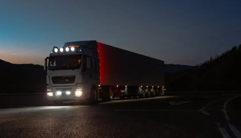 Ciężarówka z naczepą jedzie nocą. Zastanawiasz się, ile zarabia kierowca tira w USA?