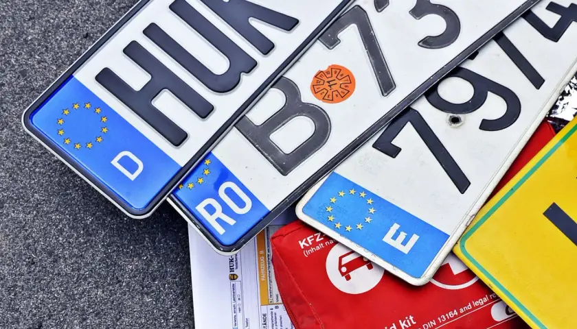 Niemieckie, rumuńskie i inne tablice rejestracyjne państw UE leżą obok apteczki.