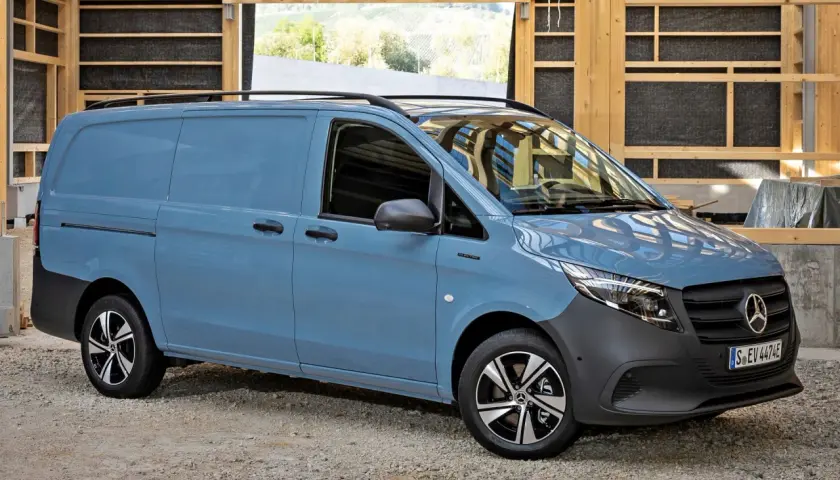 Niebieski Mercedes Vito stoi na żwirowym podłożu, w tle drewniana konstrukcja.