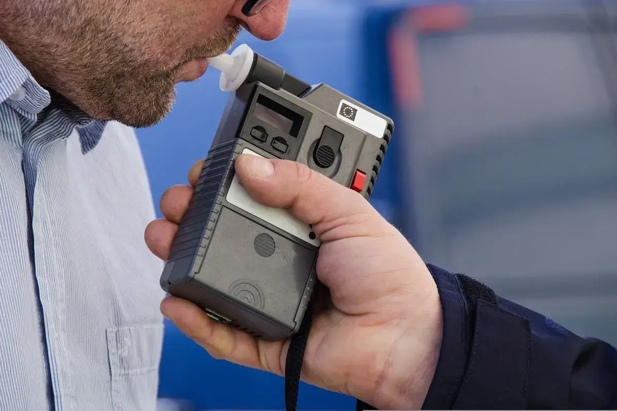 Badany jest mężczyzna z zarostem, który dmucha w alkomat. Czy pracodawca może sprawdzać alkomatem? To pytanie nurtuje wielu pracowników.