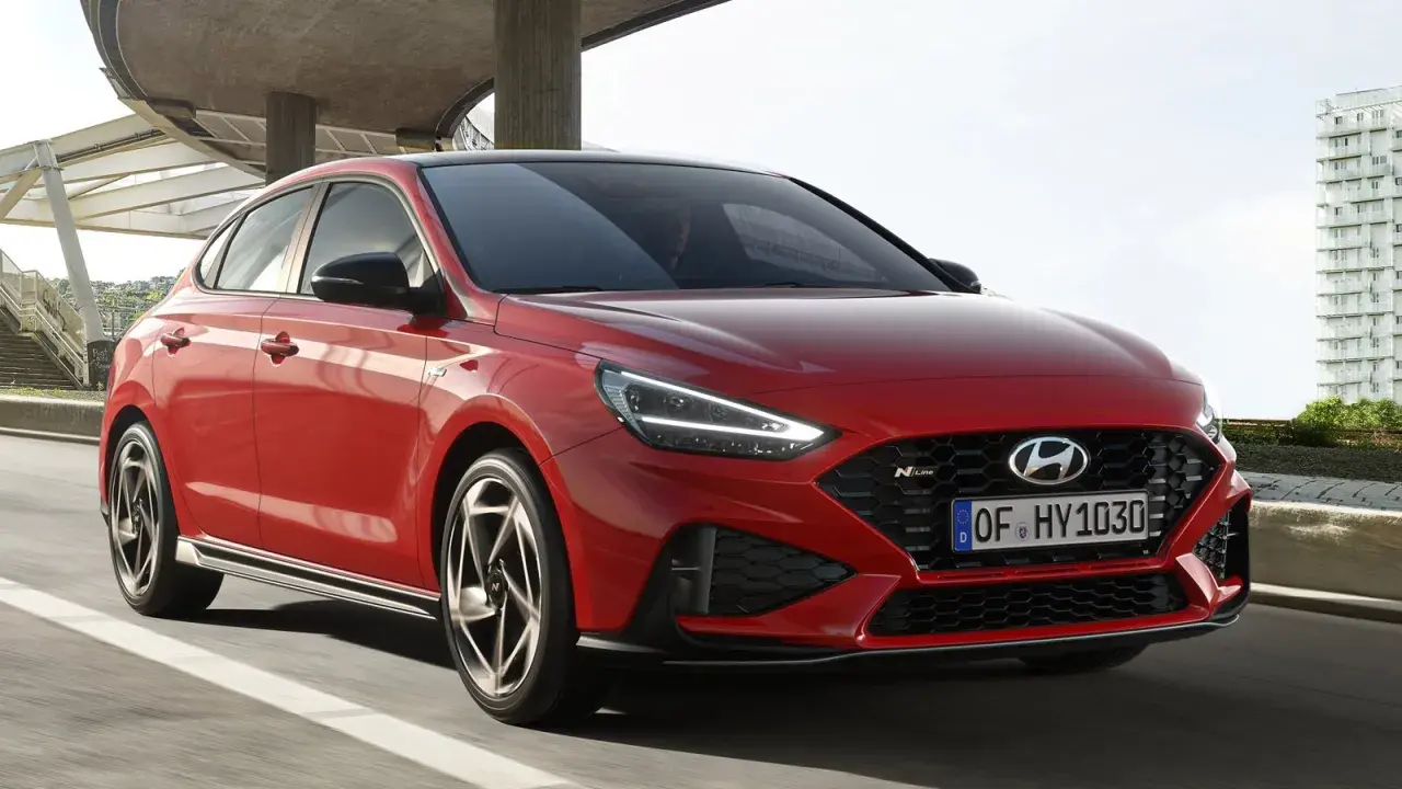 Czerwony Hyundai i30 N Line w ruchu, z widocznym przodem i bokiem.