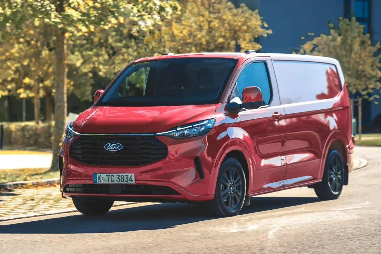Czerwony Ford Transit Custom w ruchu. Zastanawiasz się nad jego pojemnością baku? Ten van jest gotowy na długie trasy.
