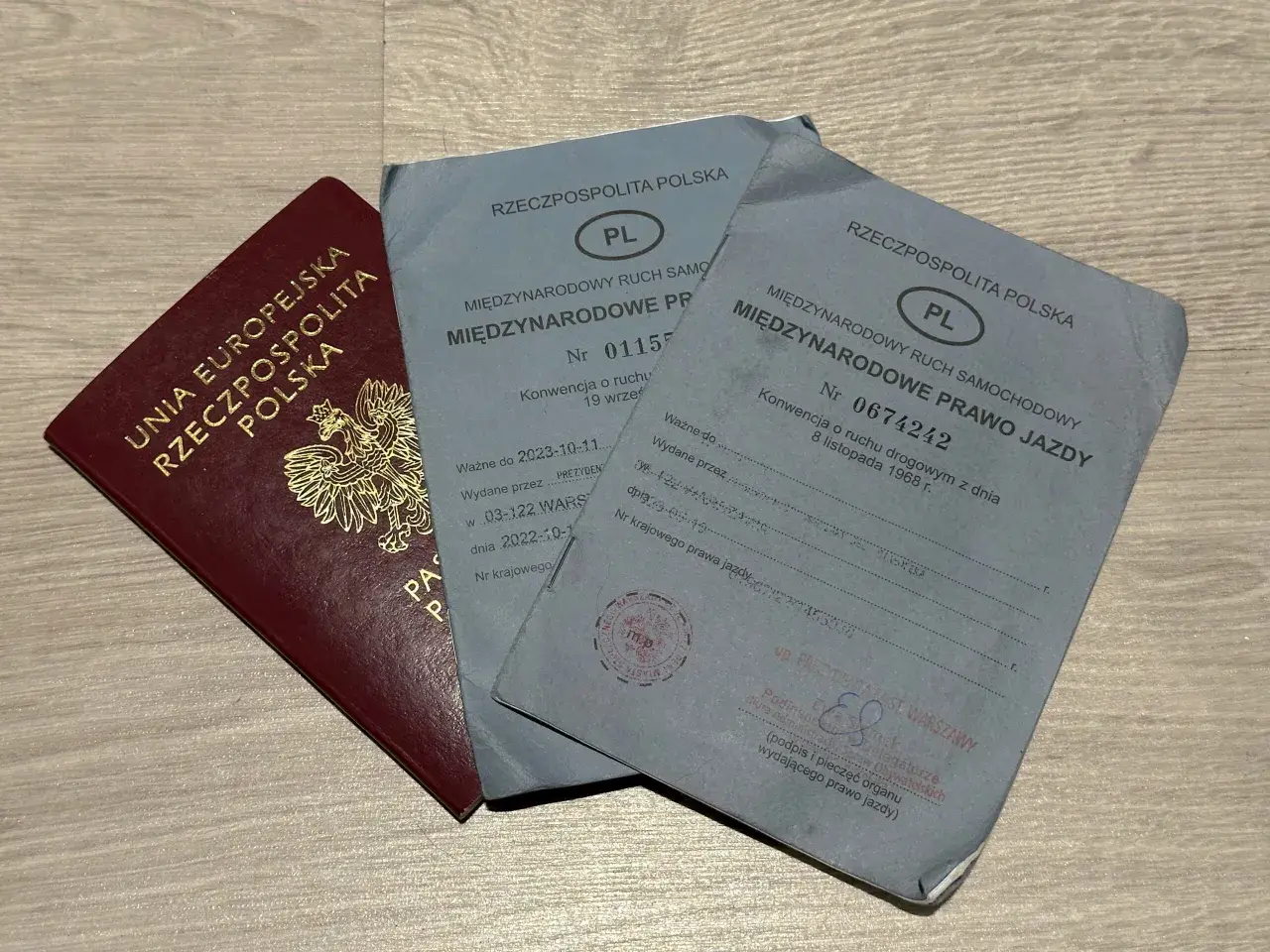 Polskie prawo jazdy międzynarodowe, wydane w Warszawie, obok paszportu.