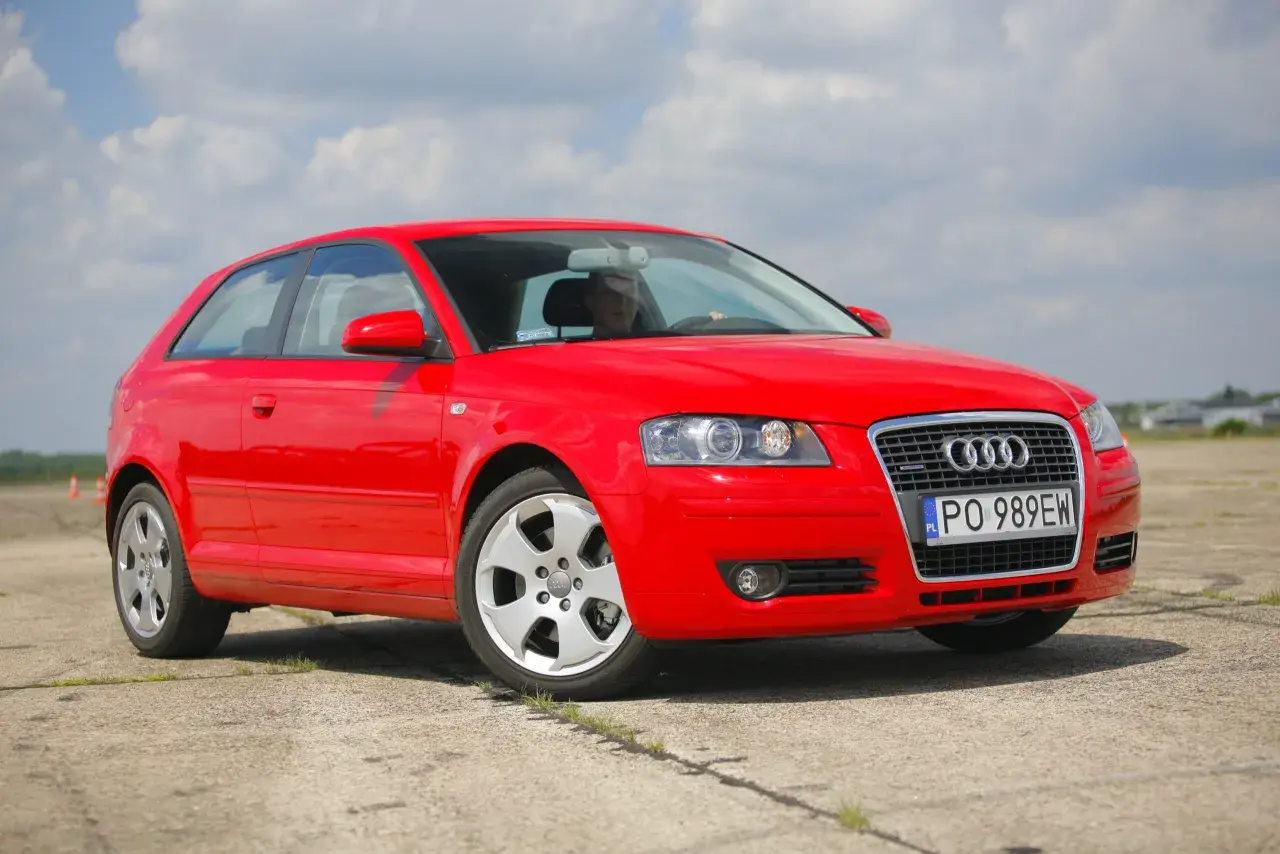 Czerwone Audi A3 8P 2.0 TDI na tle błękitnego nieba z chmurami.