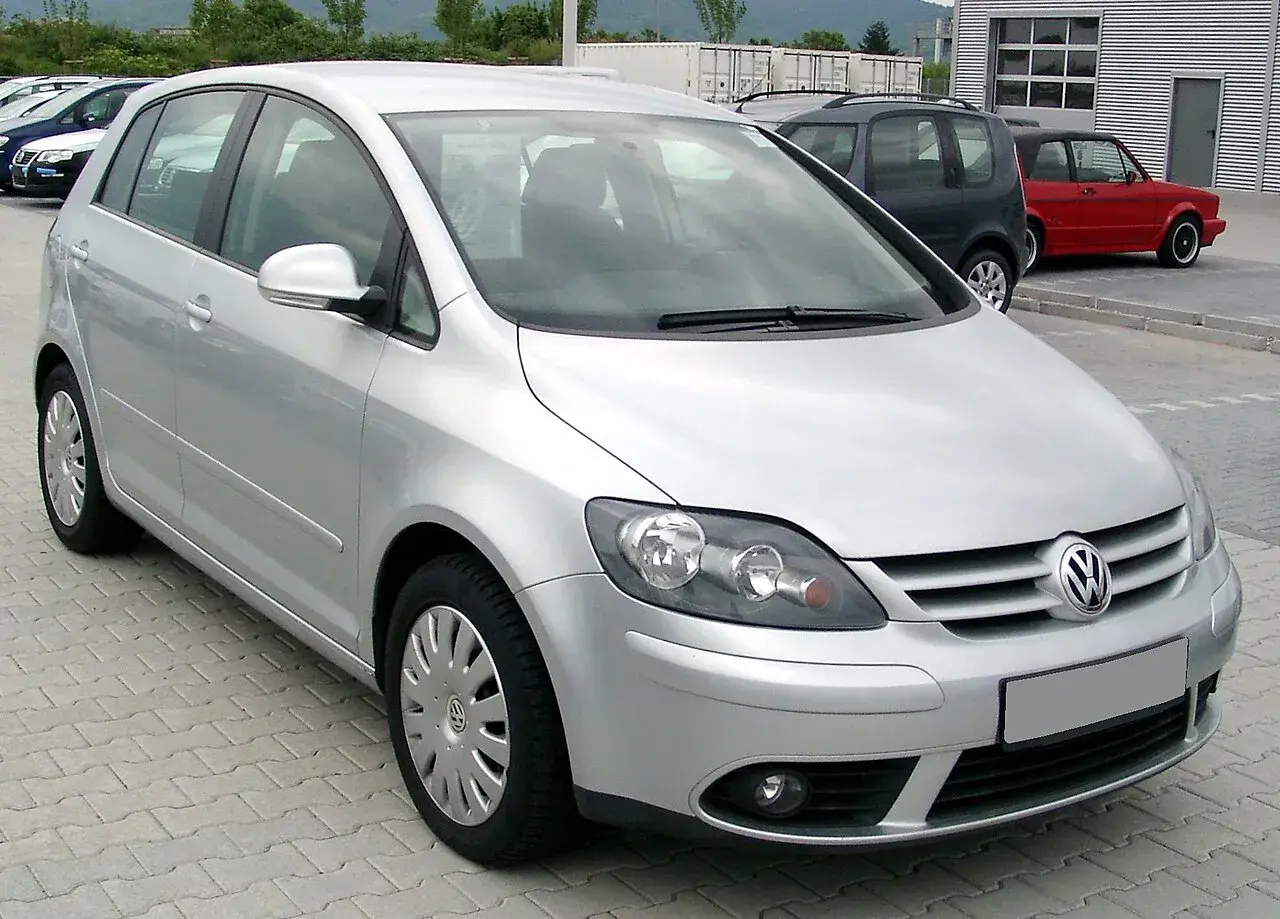 Srebrny Volkswagen Golf Plus zaparkowany na kostce brukowej.