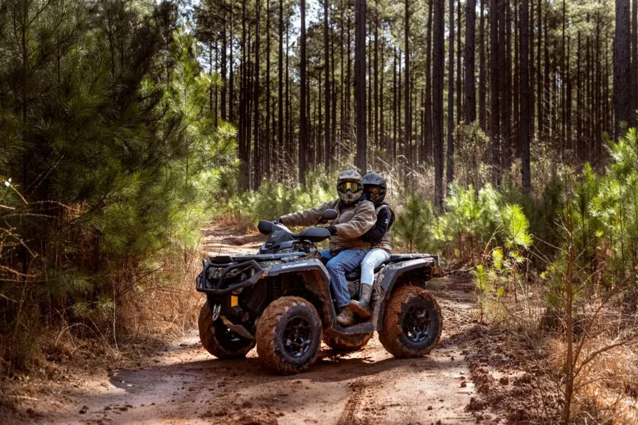 Para quad 125 potrzebne jest prawo jazdy kategorii B. Para na quadzie przemierza leśną ścieżkę.