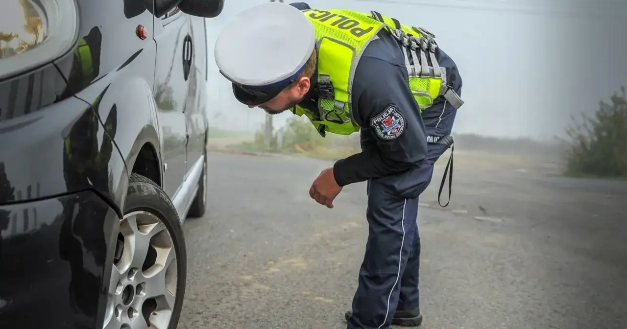 Policjant sprawdza stan techniczny pojazdu. Co jeśli samochód nie przejdzie przeglądu? Może to oznaczać problemy na drodze.