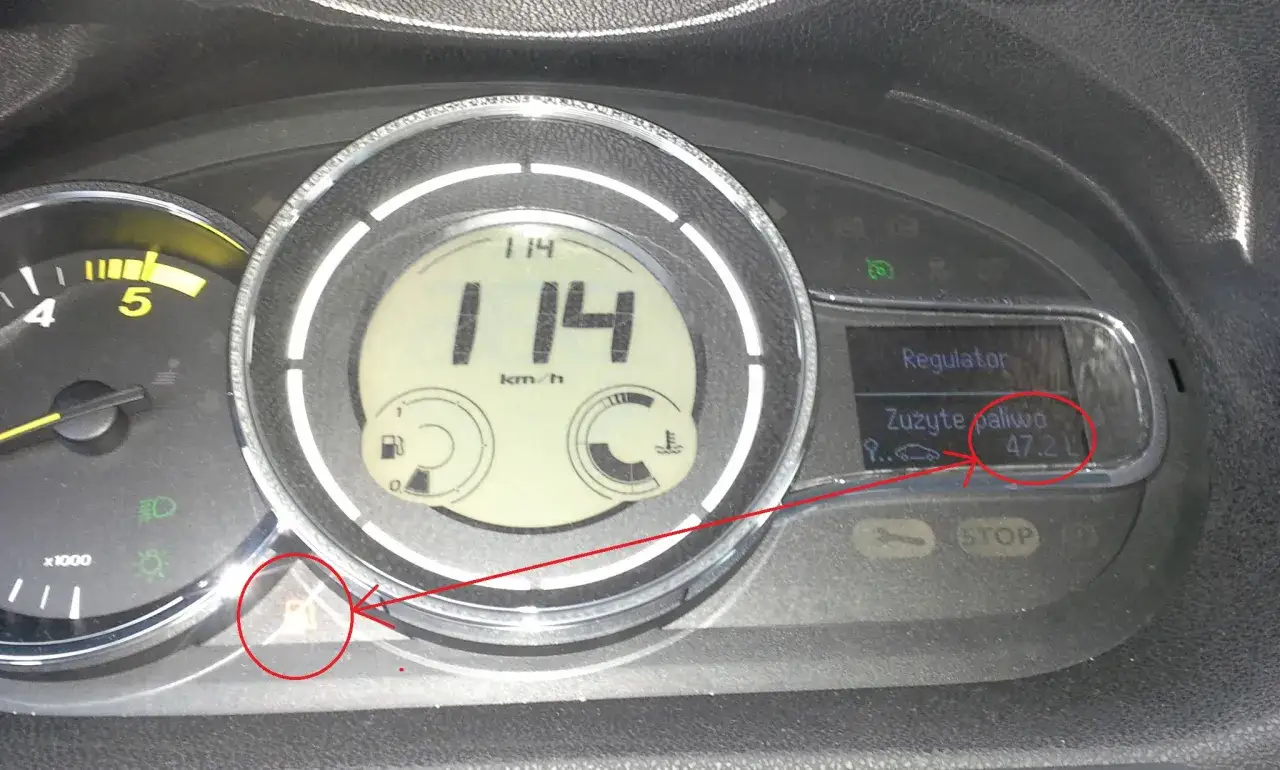 Na desce rozdzielczej Renault Megane 2 widać zużycie paliwa 47.2 L. Kontrolka rezerwy paliwa jest zapalona.