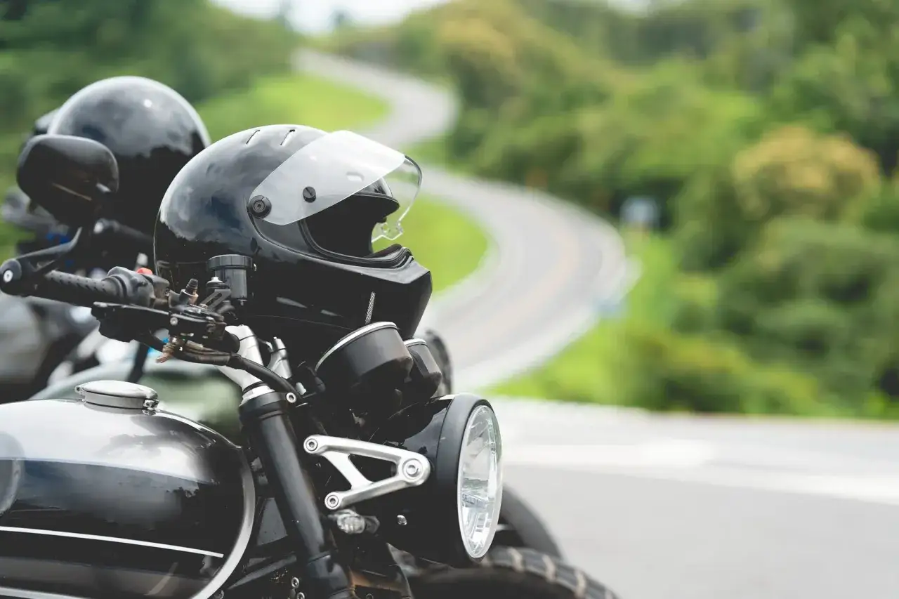 Dwa motocykle i kaski czekają na przejażdżkę po krętej drodze. Zastanawiasz się, jakie prawo jazdy na motor będzie potrzebne?