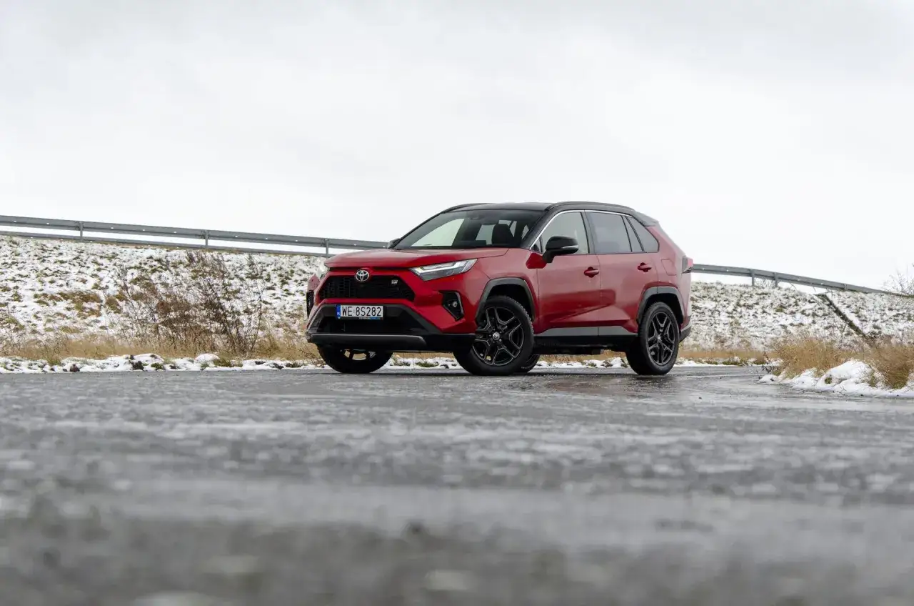 Czerwona Toyota RAV4 na mokrej drodze zimą. Zastanawiasz się nad jej pojemnością baku?