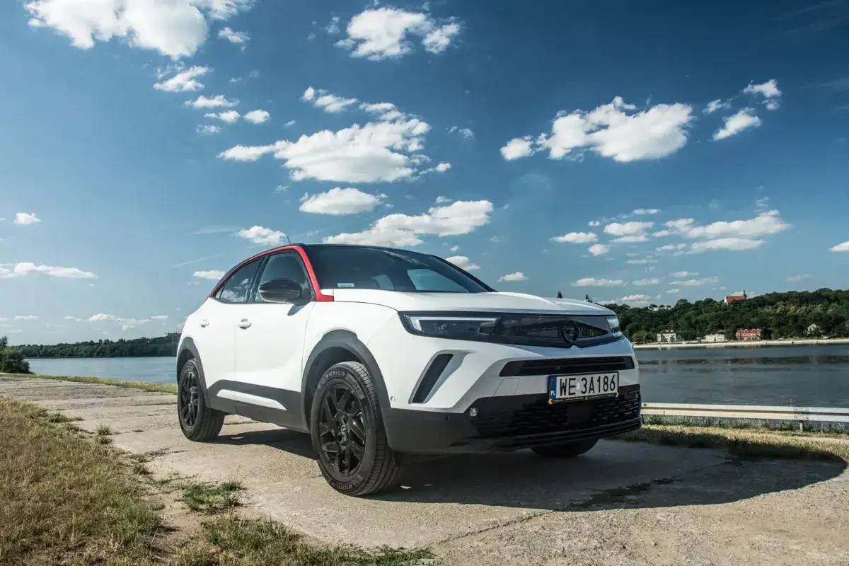 Biały Opel Mokka z czerwonym dachem stoi nad rzeką. Zastanawiasz się nad opel mokka pojemność baku?