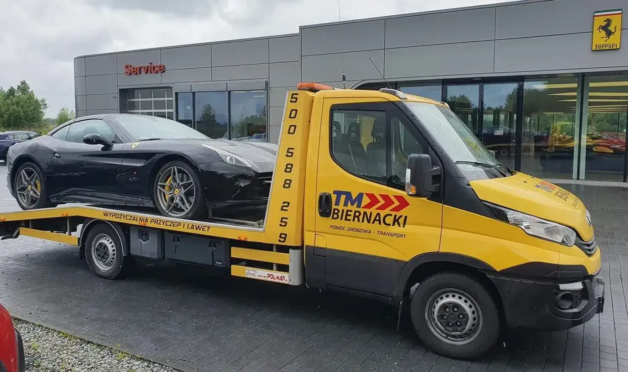 Czarny Ferrari na żółtej lawecie pomocy drogowej. Szybka reakcja HDI Assistance w akcji.