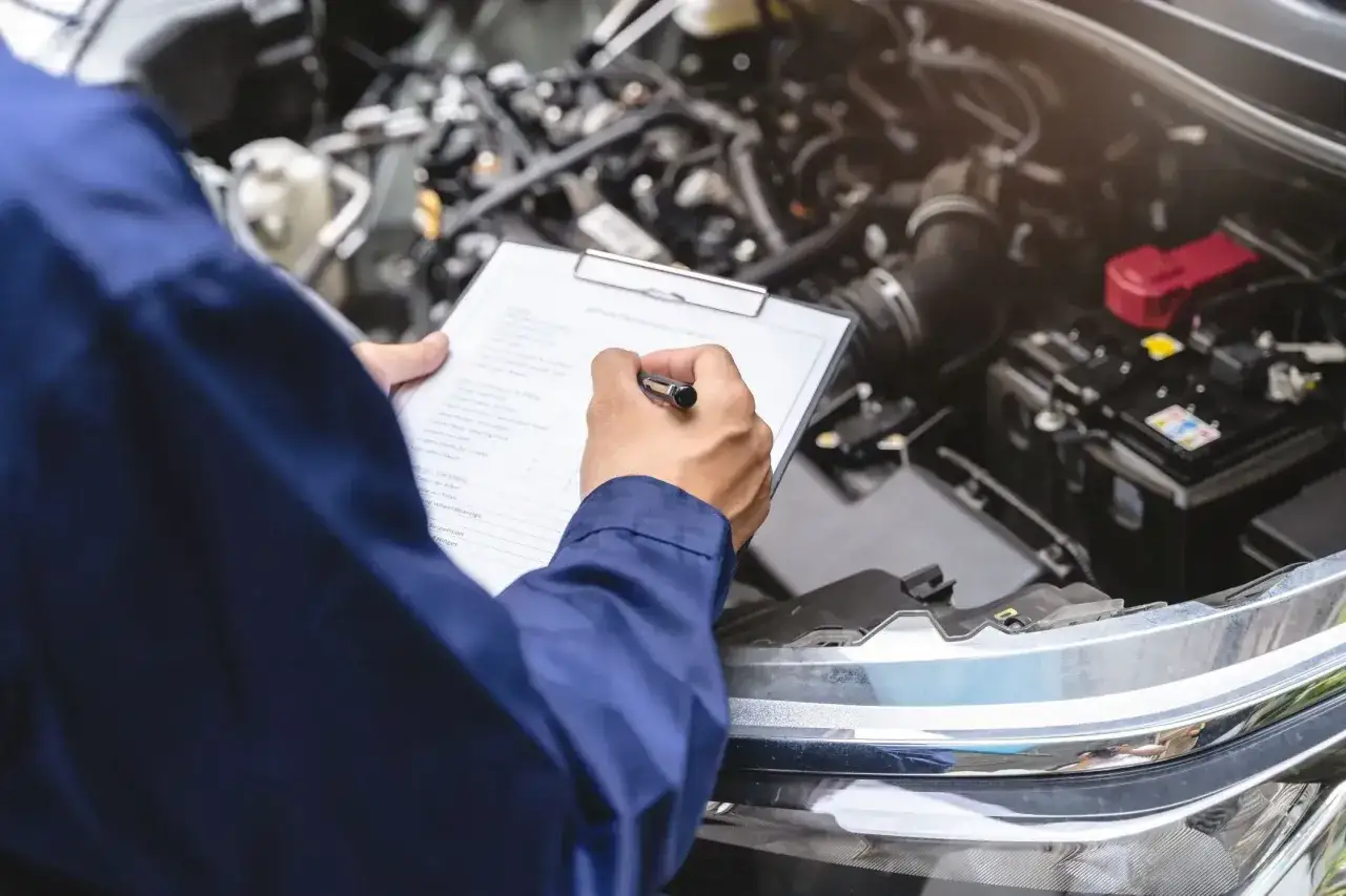 Mechanik sprawdza listę kontrolną przy silniku. Co jeśli samochód nie przejdzie przeglądu?