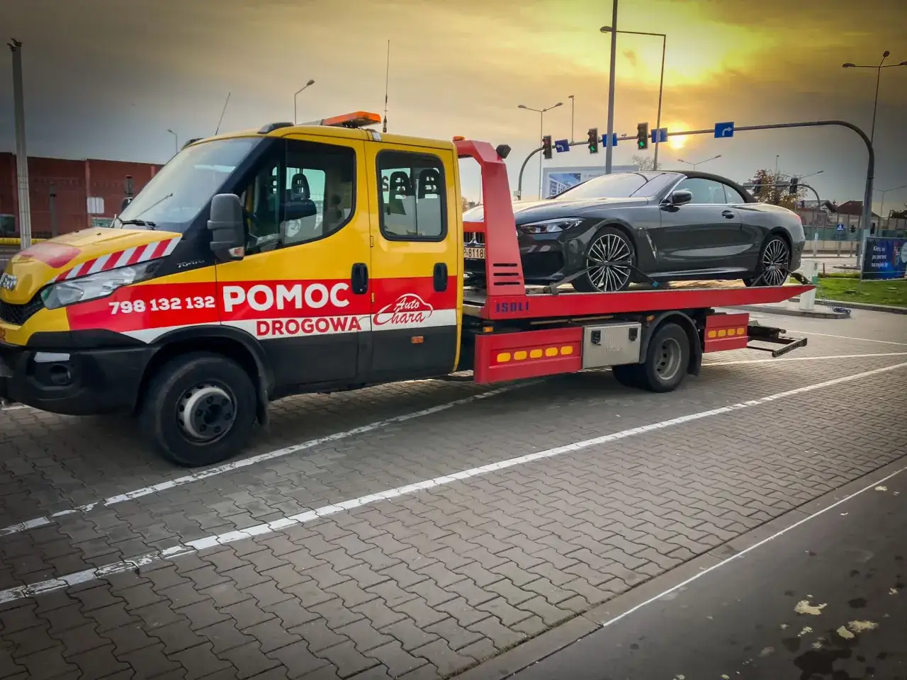 Pomoc drogowa z assistance warta transportuje luksusowego kabrioleta.